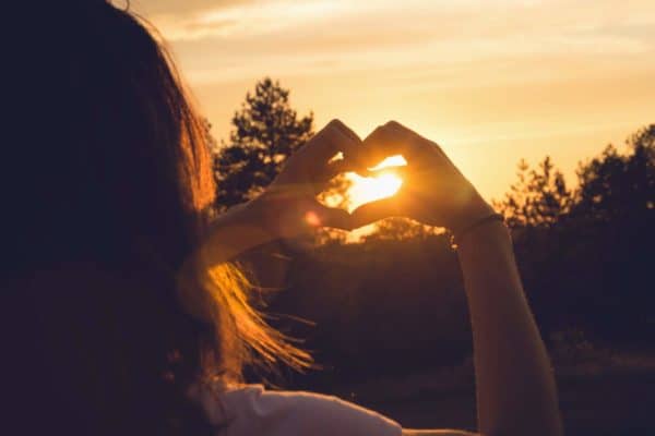 Woman makes heart with hands in sunset. Healthy people  lifestyle. Woman makes heart with hands. Nature lifestyle. Health. Lifestyle. Concept of healthy lifestyle. Happy people. Healthy people. Happiness concept. Young people.