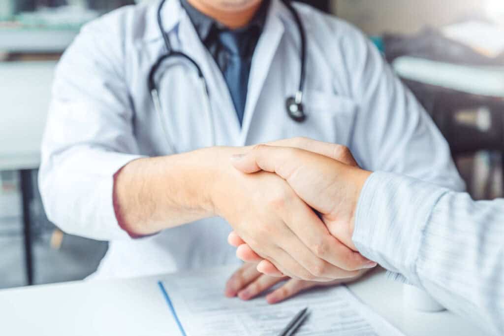 Confident Doctor shaking hands with patients talk in the hospital
